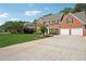 Two-story brick home with a two car garage, showcasing an expansive driveway and manicured front lawn at 75 Hunters Ct, Dallas, GA 30157
