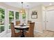 Cozy kitchen nook with a dining table, wicker chairs, and bright windows overlooking a well-maintained yard at 75 Hunters Ct, Dallas, GA 30157