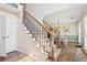 Elegant staircase with wooden and metal accents, leading to an adjacent dining room with natural light at 75 Hunters Ct, Dallas, GA 30157