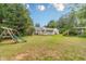 Expansive backyard with play set, pool, mature trees, and patio at 123 Chippewa Run, Auburn, GA 30011