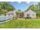 Landscaped backyard featuring a pool, covered patio, and mature trees at 123 Chippewa Run, Auburn, GA 30011
