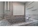 A close up of the bathroom featuring a soaking tub with decorative gray and white mosaic tile at 123 Chippewa Run, Auburn, GA 30011