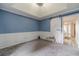 Elegant bedroom with a tray ceiling, stylish barn door, wainscoting, and soft carpet flooring at 123 Chippewa Run, Auburn, GA 30011