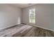 This bedroom offers gray walls, wood-look flooring, and natural light from a window at 123 Chippewa Run, Auburn, GA 30011