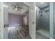 Spacious bedroom with gray wood floors connecting to a bathroom with a tiled walk-in shower at 123 Chippewa Run, Auburn, GA 30011