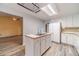 Bright kitchen with white cabinets, island with sink, white refrigerator, and adjacent breakfast area at 123 Chippewa Run, Auburn, GA 30011