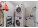 Laundry room featuring a stacked washer and dryer, shelving, and a small ironing board at 123 Chippewa Run, Auburn, GA 30011