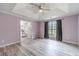 Main bedroom featuring tray ceilings, a fan, and an attached bathroom at 123 Chippewa Run, Auburn, GA 30011