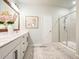 Bright bathroom with a double sink vanity, wood framed mirror, and a glass-enclosed shower at 128 Madison Bnd, Woodstock, GA 30188