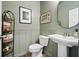 Charming powder room features a pedestal sink, stylish decor, and sage green walls at 128 Madison Bnd, Woodstock, GA 30188