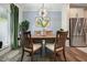 Dining room with wood table, stainless refrigerator, modern lighting, and green decor at 128 Madison Bnd, Woodstock, GA 30188