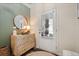 Stylish foyer with decorative chest, mirror, and accent wall at 128 Madison Bnd, Woodstock, GA 30188