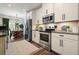 Stylish kitchen features stainless steel appliances and white cabinets at 128 Madison Bnd, Woodstock, GA 30188
