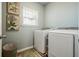 Bright laundry room with modern washer and dryer, decor, and a window at 128 Madison Bnd, Woodstock, GA 30188