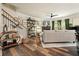 Spacious living room with hardwood floors, staircase, and comfortable seating at 128 Madison Bnd, Woodstock, GA 30188