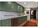 Galley kitchen featuring olive green cabinetry, stainless appliances, and a large marble countertop space at 2660 Peachtree Rd # 6A, Atlanta, GA 30305