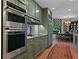 Well-equipped kitchen with green cabinets, modern stainless steel appliances, and a view into the dining area at 2660 Peachtree Rd # 6A, Atlanta, GA 30305