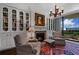 Cozy living room featuring a fireplace, bookshelves, comfortable chairs, and access to the balcony at 2660 Peachtree Rd # 6A, Atlanta, GA 30305