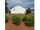 View of backyard with shrubs and healthy grass, showing house elevation at 3848 Hester St, Duluth, GA 30097