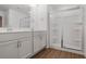 Features a double vanity, a glass-enclosed shower with built-in shelving and a wood look floor at 3848 Hester St, Duluth, GA 30097
