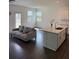 Open-concept kitchen and living room with hardwood floors and a large island at 3848 Hester St, Duluth, GA 30097