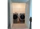 Open doorway into the laundry room with updated side-by-side washer and dryer units at 3848 Hester St, Duluth, GA 30097