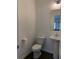 A powder room featuring a pedestal sink, mirror, and modern lighting fixtures for a touch of convenience at 3848 Hester St, Duluth, GA 30097