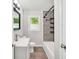 Stylish bathroom with gray tiled shower, modern vanity, and a window with a green, leafy view at 4289 Post Rd, Winston, GA 30187
