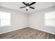 Spacious bedroom with modern fan, two windows and wood-look flooring at 4289 Post Rd, Winston, GA 30187