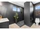 Contemporary bathroom with dark walls, stone shower floor, floating toilet and minimalist aesthetic at 5370 Greenleaf Sw Dr, Mableton, GA 30126