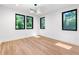 Bright bedroom featuring hardwood floors, modern light fixture and large windows with natural light at 5370 Greenleaf Sw Dr, Mableton, GA 30126