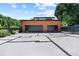 Modern two-car garage featuring a stylish wood design, black trim, and a unique stone-lined driveway at 5370 Greenleaf Sw Dr, Mableton, GA 30126