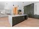 Open kitchen with marble countertop island, custom green cabinets, wood accents, and stainless steel appliances at 5370 Greenleaf Sw Dr, Mableton, GA 30126