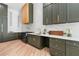Bright kitchen featuring marble backsplash, custom green cabinets, and stainless steel appliances at 5370 Greenleaf Sw Dr, Mableton, GA 30126
