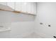 Bright laundry room featuring white cabinets with gold hardware and white walls at 5370 Greenleaf Sw Dr, Mableton, GA 30126