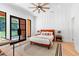 Sun-filled bedroom with stylish accent wall, ceiling fan, modern décor, and access door to the back yard at 5370 Greenleaf Sw Dr, Mableton, GA 30126