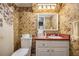 Bathroom with patterned wall paper, toilet, sink, and mirror at 5491 Valley Brook Road Southeast Se Rd, Mableton, GA 30126