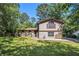 Charming split-level home featuring stone accents, a well-manicured lawn, and mature trees under a clear blue sky at 5491 Valley Brook Road Southeast Se Rd, Mableton, GA 30126