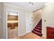 Hallway featuring tile floors, view of kitchen, and stairs with dark red carpeting, accented by white trim at 5491 Valley Brook Road Southeast Se Rd, Mableton, GA 30126