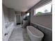 Elegant bathroom features marble floors, a soaking tub, double vanity, and a glass shower at 8239 High Lake Ter, Covington, GA 30014