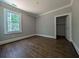Bedroom featuring hardwood floors, a large window with natural light, and a closet at 8239 High Lake Ter, Covington, GA 30014