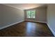 Spacious bedroom featuring hardwood floors, a window, and neutral paint tones at 8239 High Lake Ter, Covington, GA 30014