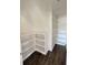 Walk-in closet with custom built-in shelving and hardwood flooring at 8239 High Lake Ter, Covington, GA 30014