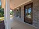 Spacious front porch showcasing brick accents, stylish columns, and an elegant front door at 8239 High Lake Ter, Covington, GA 30014