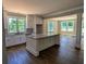 A modern kitchen featuring white cabinets, granite countertops, and a large central island with hardwood flooring at 8239 High Lake Ter, Covington, GA 30014
