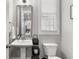 Charming half bathroom featuring a pedestal sink, decorative mirror, and neutral paint, enhancing its appeal at 914 Martin Nw St, Atlanta, GA 30315
