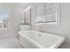 Bright bathroom with soaking tub under a window offering natural light at 914 Martin Nw St, Atlanta, GA 30315