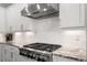 Kitchen with stainless steel range hood, white cabinets, and a gas cooktop for efficient cooking at 914 Martin Nw St, Atlanta, GA 30315
