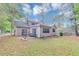 Rear exterior view with a cozy patio and expansive, tree-lined backyard at 916 Forest Pointe Way, Jonesboro, GA 30238