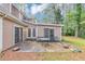 Exterior view of the home featuring a backyard patio with seating and mature trees at 916 Forest Pointe Way, Jonesboro, GA 30238